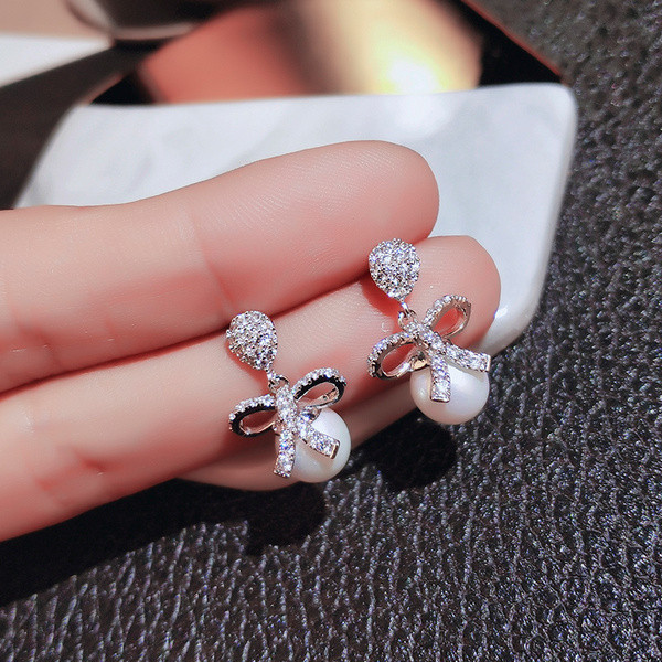 Vienkārši sieviešu auskari ar pērli un lenti ar akmeņiem