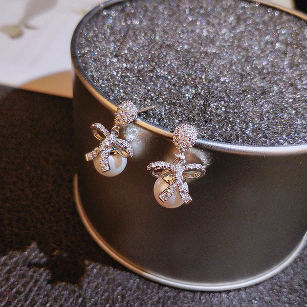 Vienkārši sieviešu auskari ar pērli un lenti ar akmeņiem