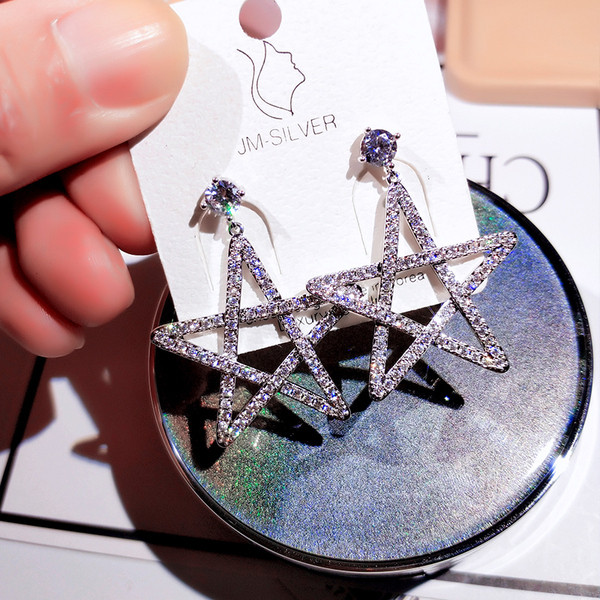 Sieviešu auskari zvaigznes formā, pārklāti ar akmeņiem