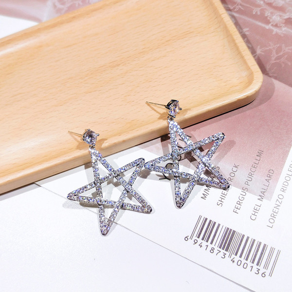 Sieviešu auskari zvaigznes formā, pārklāti ar akmeņiem