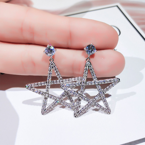 Sieviešu auskari zvaigznes formā, pārklāti ar akmeņiem