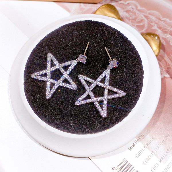 Sieviešu auskari zvaigznes formā, pārklāti ar akmeņiem