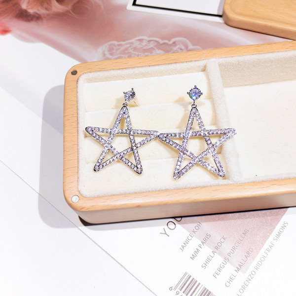 Sieviešu auskari zvaigznes formā, pārklāti ar akmeņiem
