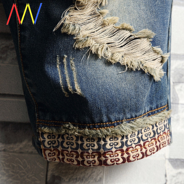 Kék színű, rövid, testhezálló farmer szakadt motívumokkal