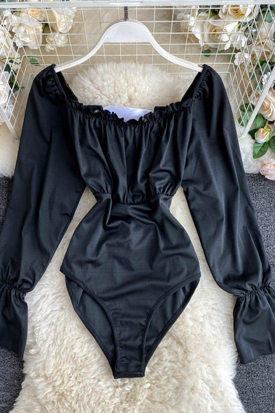 Hétköznapi női test, csupasz váll és hosszú ujjú fekete színben