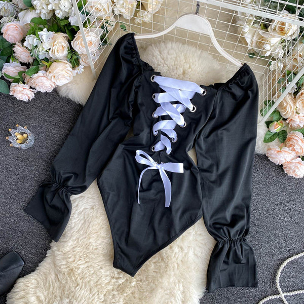 Hétköznapi női test, csupasz váll és hosszú ujjú fekete színben