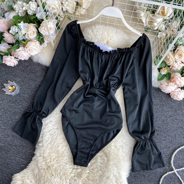 Hétköznapi női test, csupasz váll és hosszú ujjú fekete színben