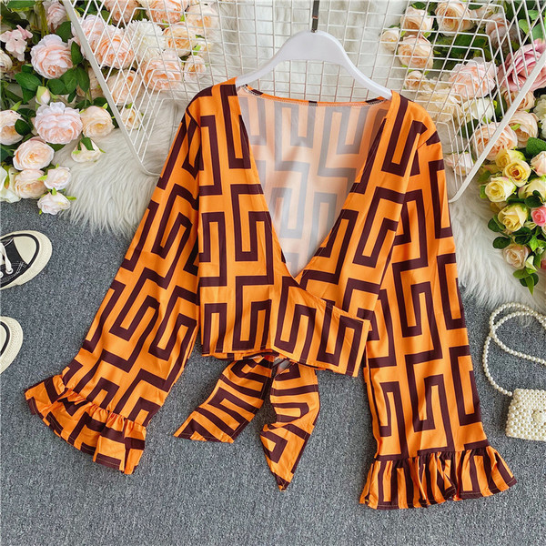 Stílusos női rövid blúz széles ujjakkal és spitz nyakkivágással