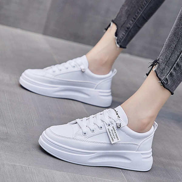 Női tornacipő emblémával és lapos talppal