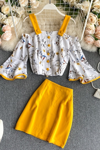 Naiste paljaste õlgadega pluusi ja kõrge vöökohaga seelikuga kollane