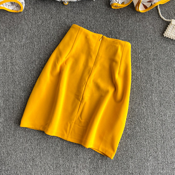 Naiste paljaste õlgadega pluusi ja kõrge vöökohaga seelikuga kollane