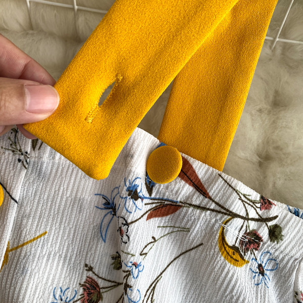 Naiste paljaste õlgadega pluusi ja kõrge vöökohaga seelikuga kollane