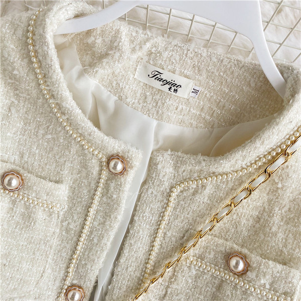 Stílusos női rövid kabát gyöngyökkel és zsebekkel