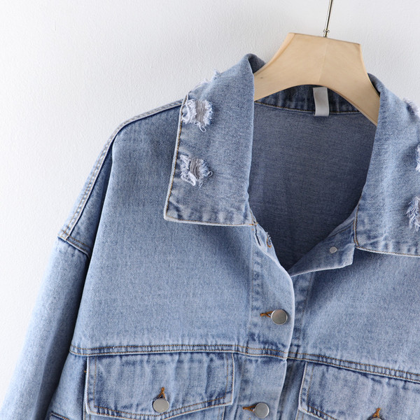 Modern női farmerdzseki zsebekkel, szakadt elemekkel