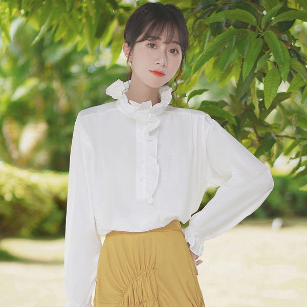 Valge kõrge kaelusega ja pikkade varrukatega naiste särk