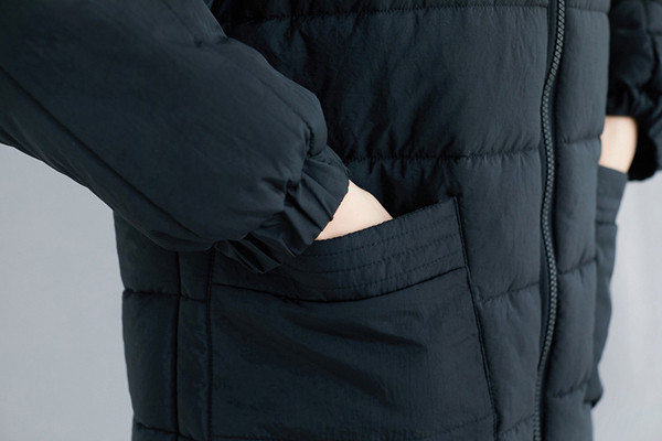 Hosszú női kabát zsebekkel és kapucnival