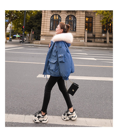 Széles modell téli női kabát kapucnival és zsebekkel