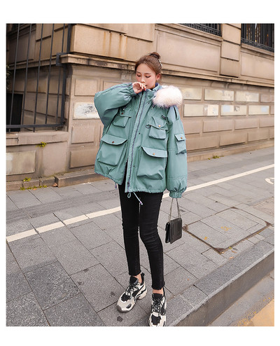 Széles modell téli női kabát kapucnival és zsebekkel