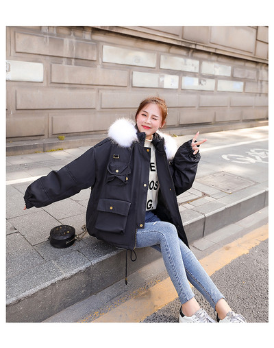 Széles modell téli női kabát kapucnival és zsebekkel