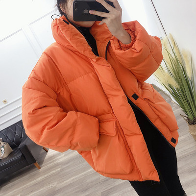 Széles téli női kabát magas gallérral és zsebekkel