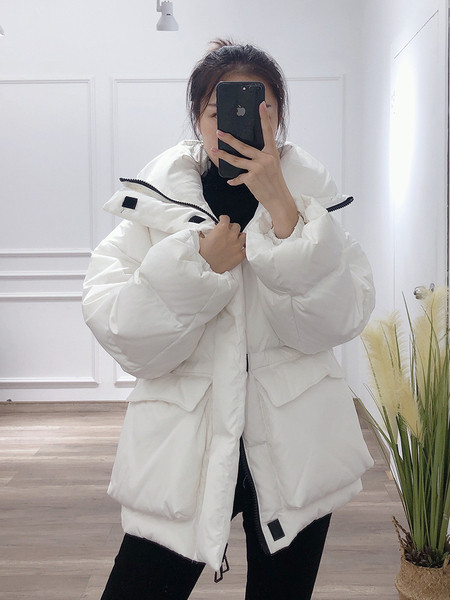 Széles téli női kabát magas gallérral és zsebekkel