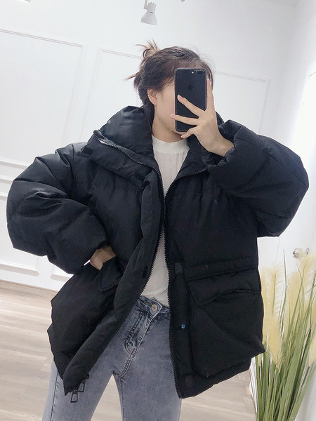 Széles téli női kabát magas gallérral és zsebekkel