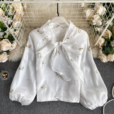 Stílusos női ing gallérján szalaggal és hímzett virágokkal