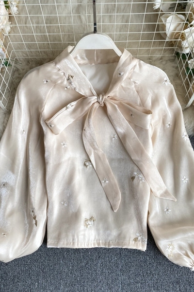 Stílusos női ing gallérján szalaggal és hímzett virágokkal