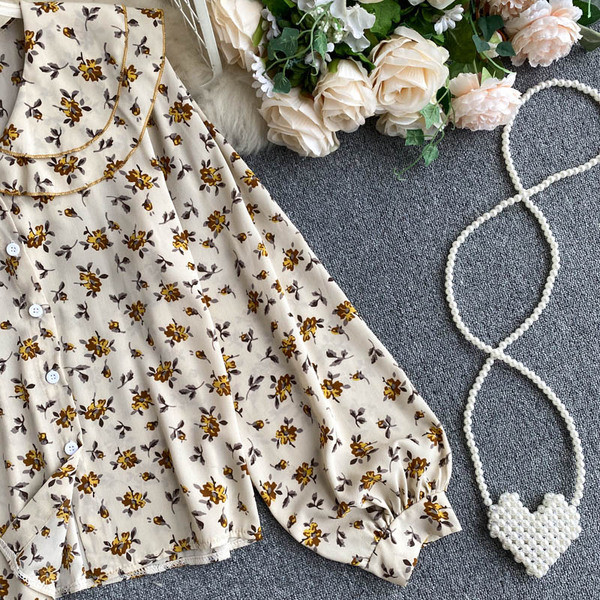 Lillede ja nööpidega naiste särk – spits-kaelus