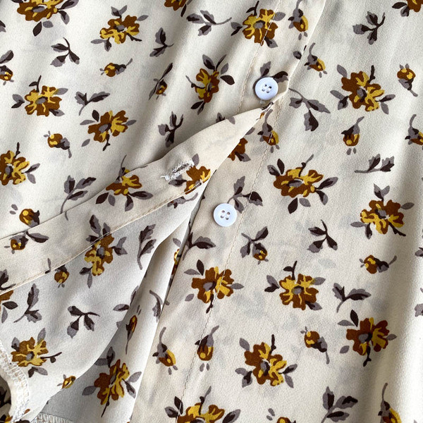 Lillede ja nööpidega naiste särk – spits-kaelus