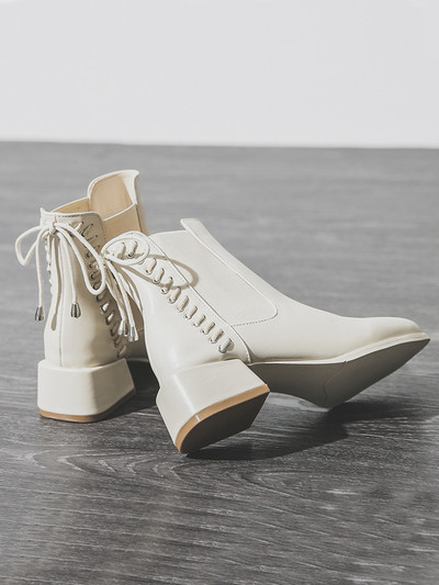 Moodsad paksu kontsaga ja dekoratiivsete paeltega naiste saapad